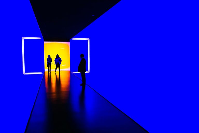 Image of brightly lit corridor with silhouetted figures in the distance