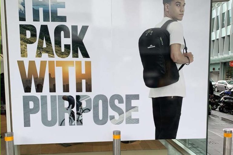 outdoor advertisement featuring a person with a backpack